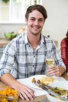 Portrait of cheerful man holding white wine glass