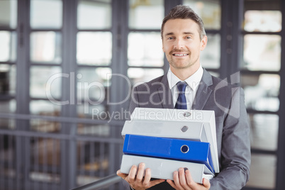 Businessman carrying files stack in office