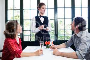 Young waitress taking an order from a couple