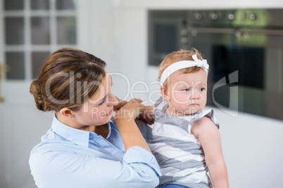 Mother carrying daughter at home