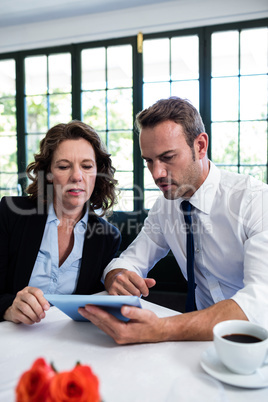 Business colleagues using a digital tablet while having a meetin