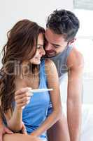 Happy romantic couple with pregnancy test