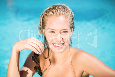 Portrait of beautiful woman leaning on poolside