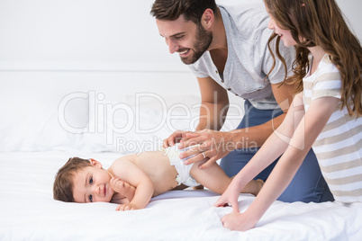 Father playing with children on bed