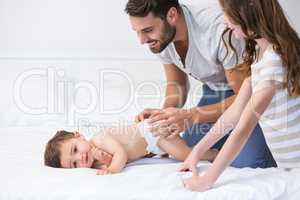 Father playing with children on bed