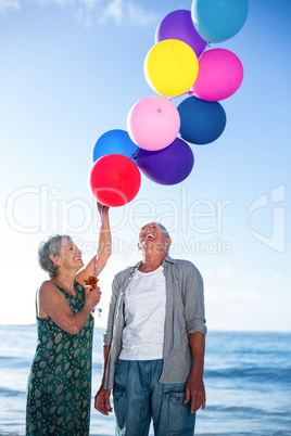 Senior couple holding balloons