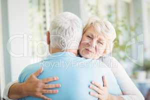 Portrait of senior woman hugging her husband