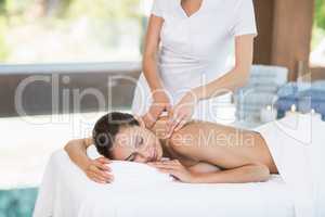 Masseur massaging young woman at health spa