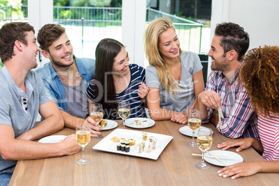 Friends enjoying while having sushi and wine