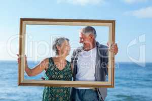 Senior couple posing with a frame