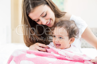 Smiling mother and baby with blanket