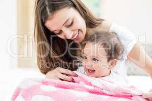 Smiling mother and baby with blanket