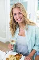 Portrait of happy woman holding white wine glass