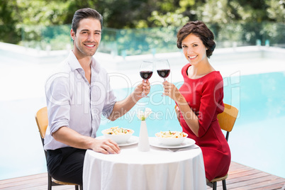 Portrait of smiling couple toasting red wine