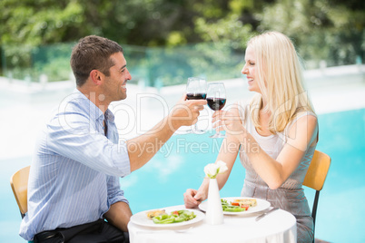 Smiling couple holding red wine