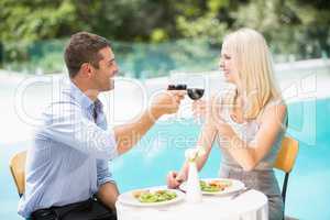 Smiling couple holding red wine