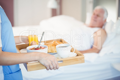Midsection of nurse with breakfast in tray