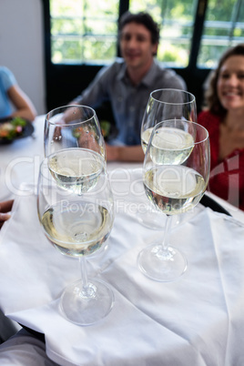 Waiter serving wine to friends in restaurant