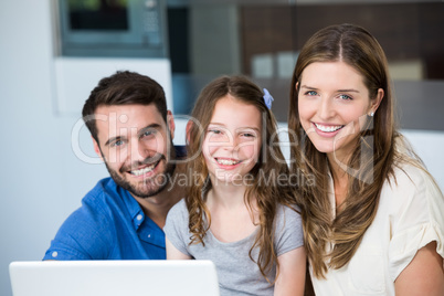 Portrait of smiling family with laptop