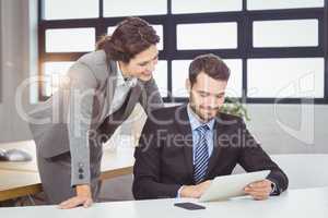 Business people discussing over laptop in office