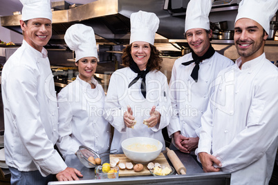 Team of chefs smiling in commercial kitchen