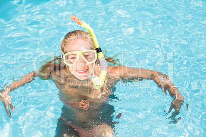 Happy woman with snorkel gear swimming in pool
