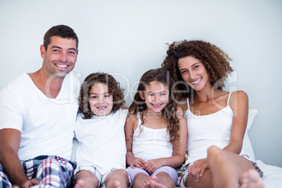 Portrait of a family sitting together on bed