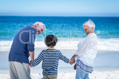 Cute boy holding his grandparents hands