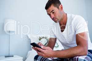 Young man typing a text message on phone
