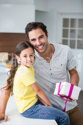 Smiling father and daughter with gift box