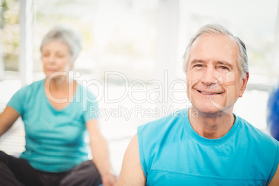 Portrait of senior man smiling with wife meditating