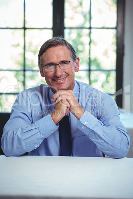 Smiling businessman leaning on a table