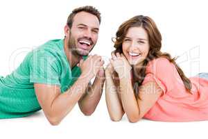 Happy young couple lying on floor looking at camera