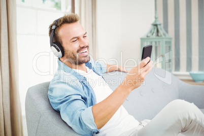 Man using smart phone while listening to music