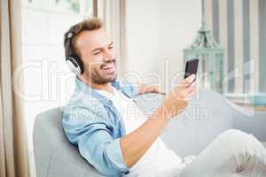 Man using smart phone while listening to music