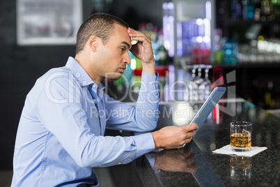 Businessman having a whisky and using laptop