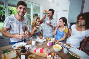 Cheerful young friends holding drinks