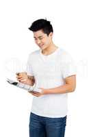 Young man having coffee and reading newspaper