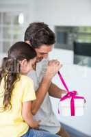 Father opening gift given by daughter
