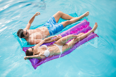 Couple relaxing on inflatable raft