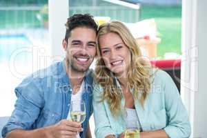 Smiling couple holding white wine glasses