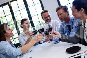 Group of businesspeople toasting wine glass during business lunc