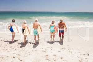 Senior friends holding surfboard