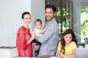 Portrait of cheerful family at desk