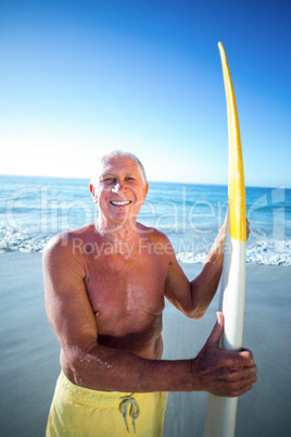 Senior man posing with a surfboard