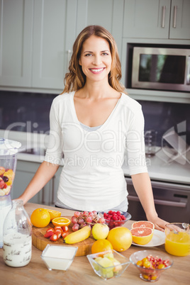 Portrait of smiling woman standing at table