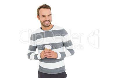 Happy young man in winter wear holding disposable coffee cup