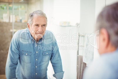 Reflection of smiling senior man on mirror