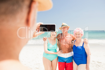 Senior man taking picture of his friends