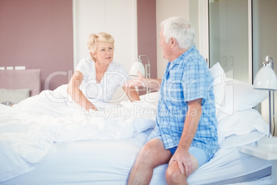 Senior couple talking in bedroom